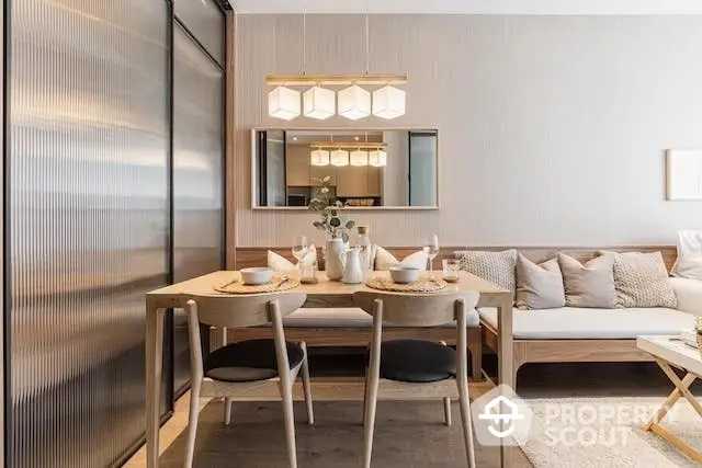 Elegantly furnished open-plan living space with a cozy dining area and modern kitchen, featuring warm lighting and tasteful decor.