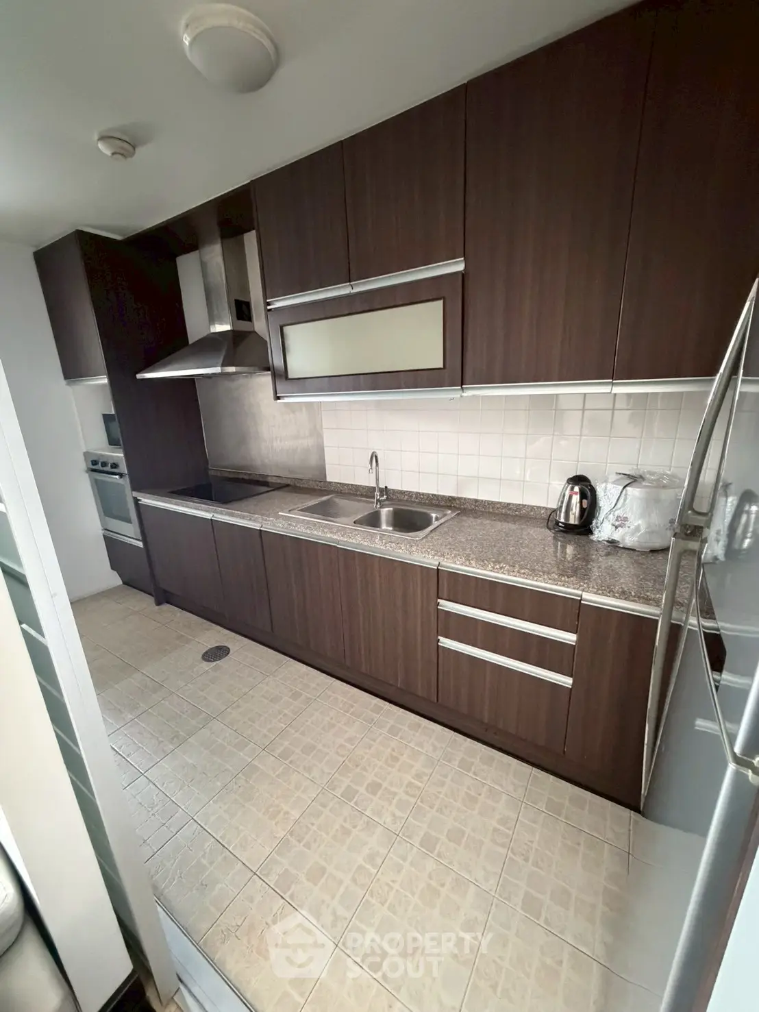Modern kitchen with sleek dark wood cabinets and stainless steel appliances