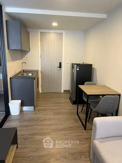 Modern compact kitchen with sleek design and cozy dining area in a stylish apartment.