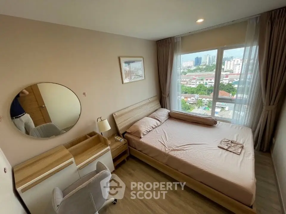 Cozy bedroom with city view, featuring a comfortable bed, stylish furniture, and large window for natural light.