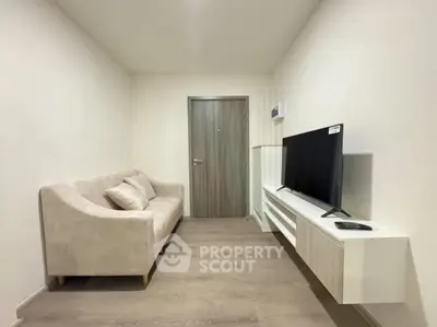 Modern living room with sleek TV setup and comfortable sofa in minimalist design.