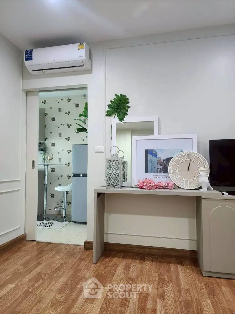 Modern interior with stylish decor and air conditioning, featuring a glimpse into a chic kitchen area.