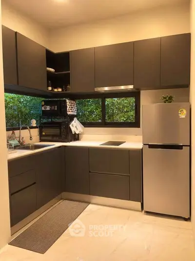 Modern kitchen with sleek cabinets and stainless steel appliances in a cozy layout.