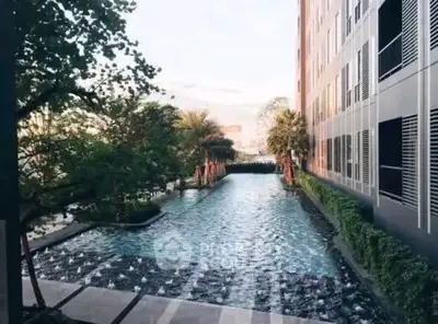 Luxurious apartment building with serene outdoor pool and lush greenery.