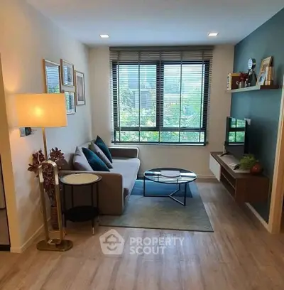 Modern living room with stylish decor and large window offering garden view.