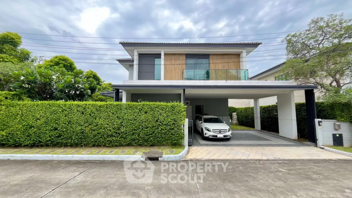 Modern two-story house with carport and lush greenery