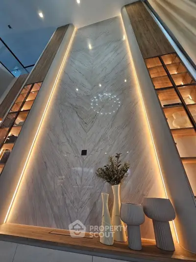 Luxurious modern interior with elegant lighting and decorative vases on a wooden shelf.