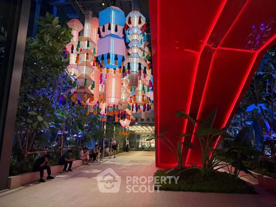 Stunning modern entrance with vibrant lighting and lush greenery, perfect for luxury real estate appeal.