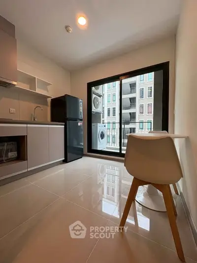 Modern kitchen with sleek appliances and balcony view in urban apartment