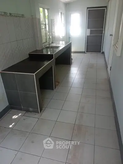 Spacious kitchen with tiled floor and modern countertops, ideal for culinary enthusiasts.