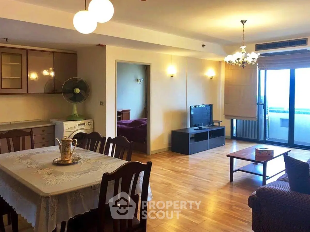 Spacious living room with dining area and balcony access in modern apartment.