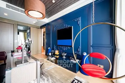Luxurious modern living room with vibrant blue accent wall and unique hanging chair.