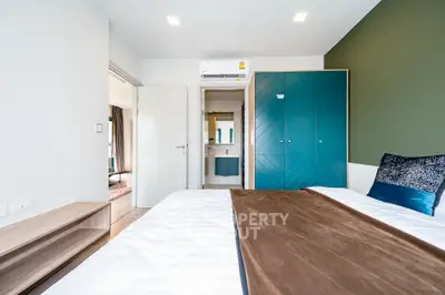 Modern bedroom with stylish wardrobe and cozy bedding in a bright apartment.
