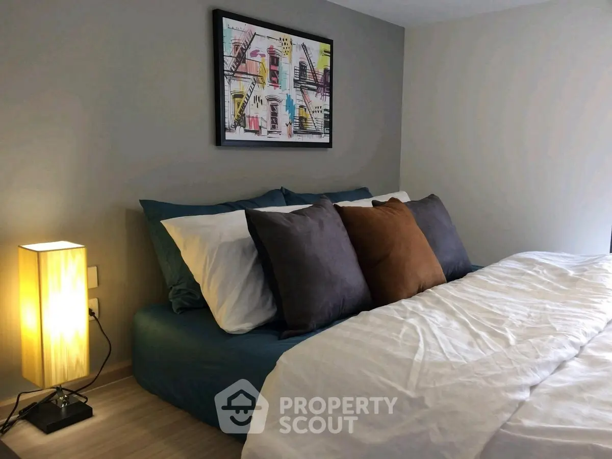 Cozy bedroom with modern decor and stylish artwork above the bed, perfect for relaxation.