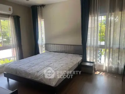 Spacious bedroom with large windows and natural light