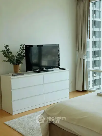 Modern bedroom with sleek white dresser and large window view