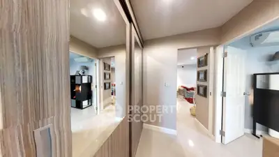 Modern hallway with sleek design and mirrored closet doors leading to a cozy living area.