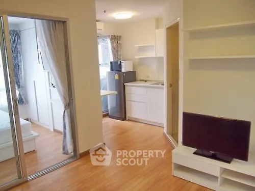 Modern apartment interior with open layout, featuring a cozy living area and compact kitchen.