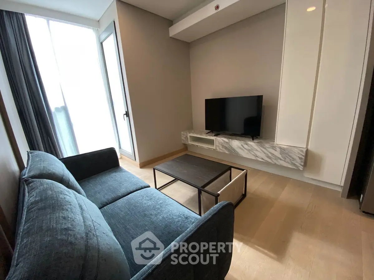 Modern living room with sleek TV setup and cozy sofa in stylish apartment.