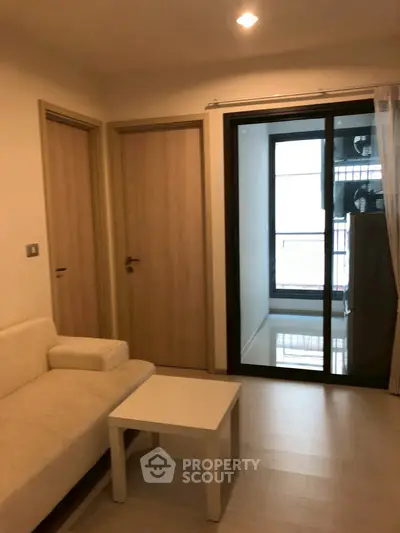 Cozy living room with modern sofa and sliding glass door to balcony