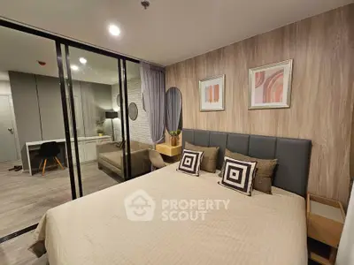 Modern bedroom with stylish decor and glass partition leading to a cozy study area.