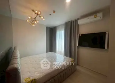 Modern bedroom with stylish lighting and wall-mounted TV, featuring a comfortable bed and elegant curtains.