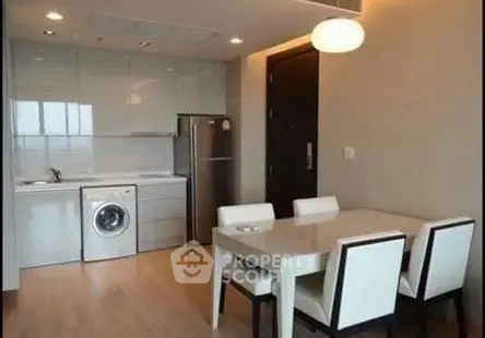 Modern kitchen and dining area with sleek appliances and elegant dining set.