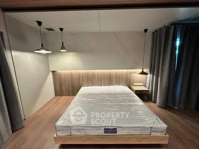 Modern bedroom with stylish lighting and sleek design, featuring a new mattress on a wooden platform bed.