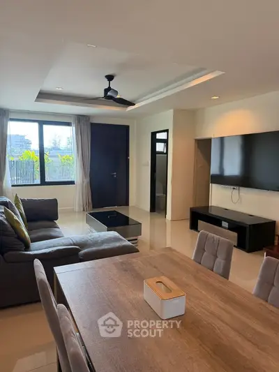 Spacious modern living room with elegant furniture and large window view.