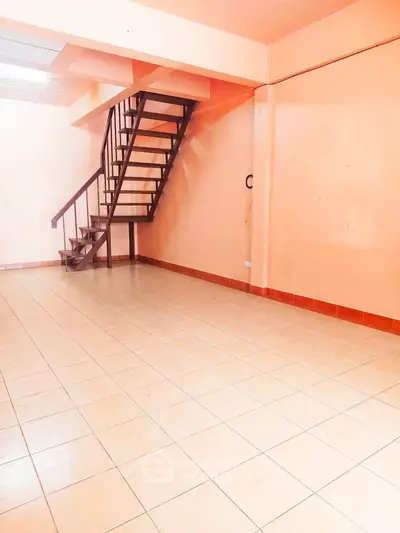 Spacious interior with modern staircase and tiled flooring, perfect for customization.