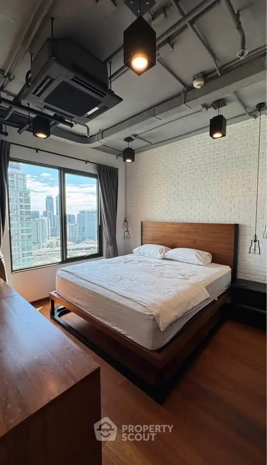 Modern bedroom with city view, featuring industrial ceiling and wooden flooring for a stylish urban living experience.