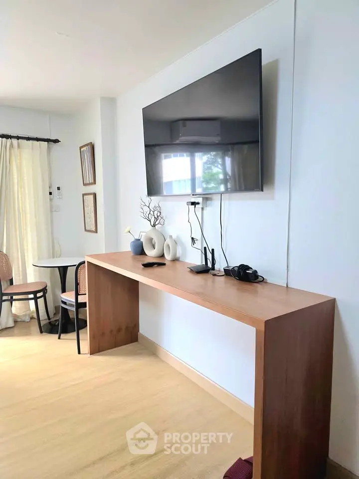 Modern living room with wall-mounted TV and stylish wooden console table.