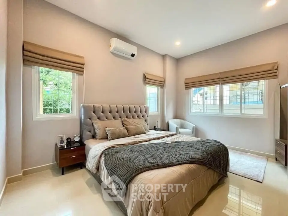 Spacious bedroom with elegant decor and natural light, featuring a plush bed and modern furnishings.