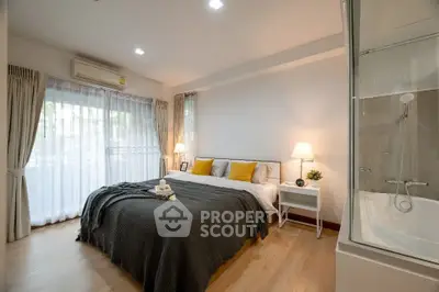 Spacious bedroom with modern decor and natural light, featuring a cozy bed and elegant furnishings.