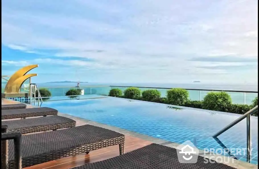 Luxurious rooftop infinity pool with stunning ocean view and modern sun loungers.