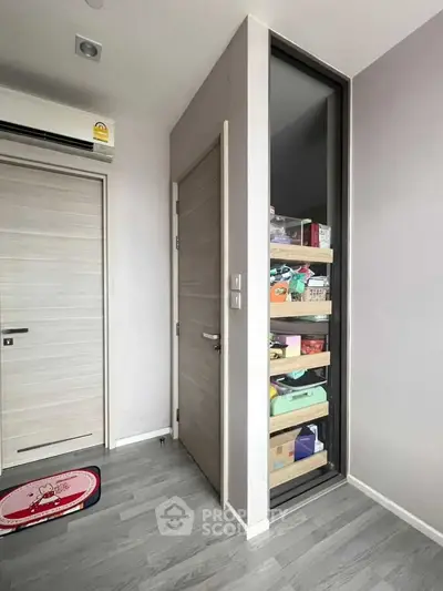Modern storage room with sleek sliding door and organized shelves in a contemporary apartment.