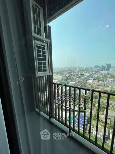 Stunning high-rise balcony view overlooking cityscape with clear skies and modern architecture.