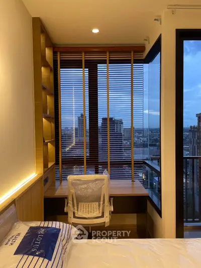 Modern bedroom with city view, featuring a cozy study nook and stylish decor.