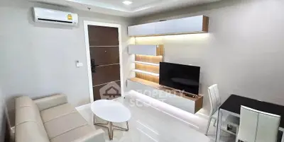 Modern living room with sleek furniture and wall-mounted TV in a cozy apartment.