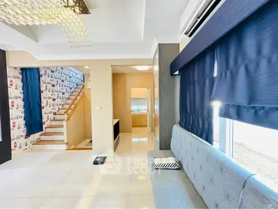 Modern living room with stylish decor and staircase in a bright, open layout home.