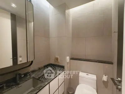 Modern bathroom with sleek black marble countertop and elegant lighting