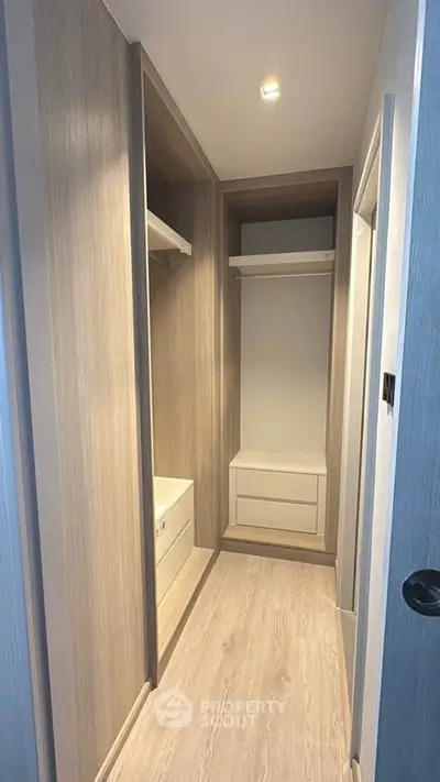 Spacious walk-in closet with modern wooden finish and ample storage space.