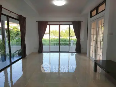 Spacious living room with large windows and garden view