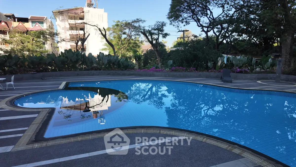 Stunning outdoor pool area with lush greenery and modern design, perfect for relaxation and leisure.