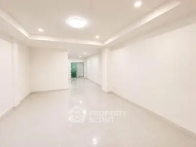 Spacious empty room with modern lighting and tiled flooring, perfect for customization.