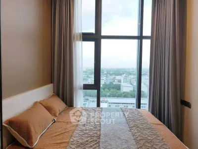 Cozy bedroom with large window offering stunning city view, perfect for relaxation and comfort.