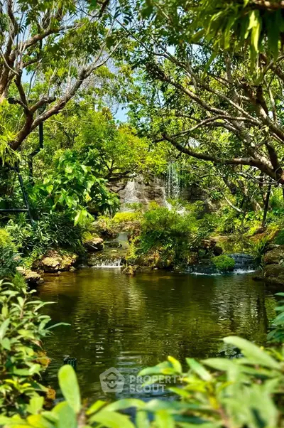 Lush garden with serene pond and waterfall, perfect for tranquil living.