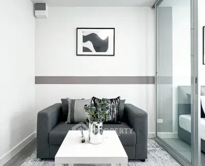 Modern living room with sleek gray sofa and stylish decor in a contemporary apartment.
