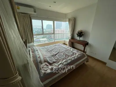 Spacious bedroom with large window offering city view and elegant decor