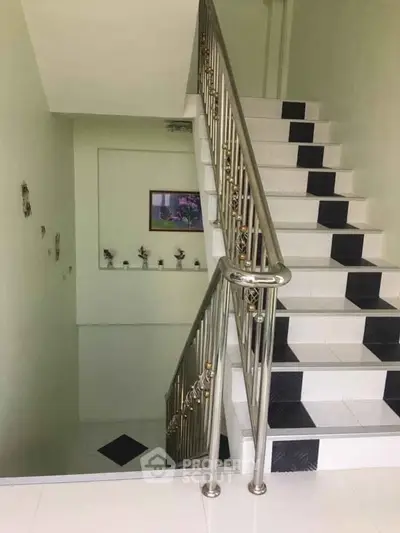 Elegant staircase with modern railing and decorative wall accents in a stylish home interior.